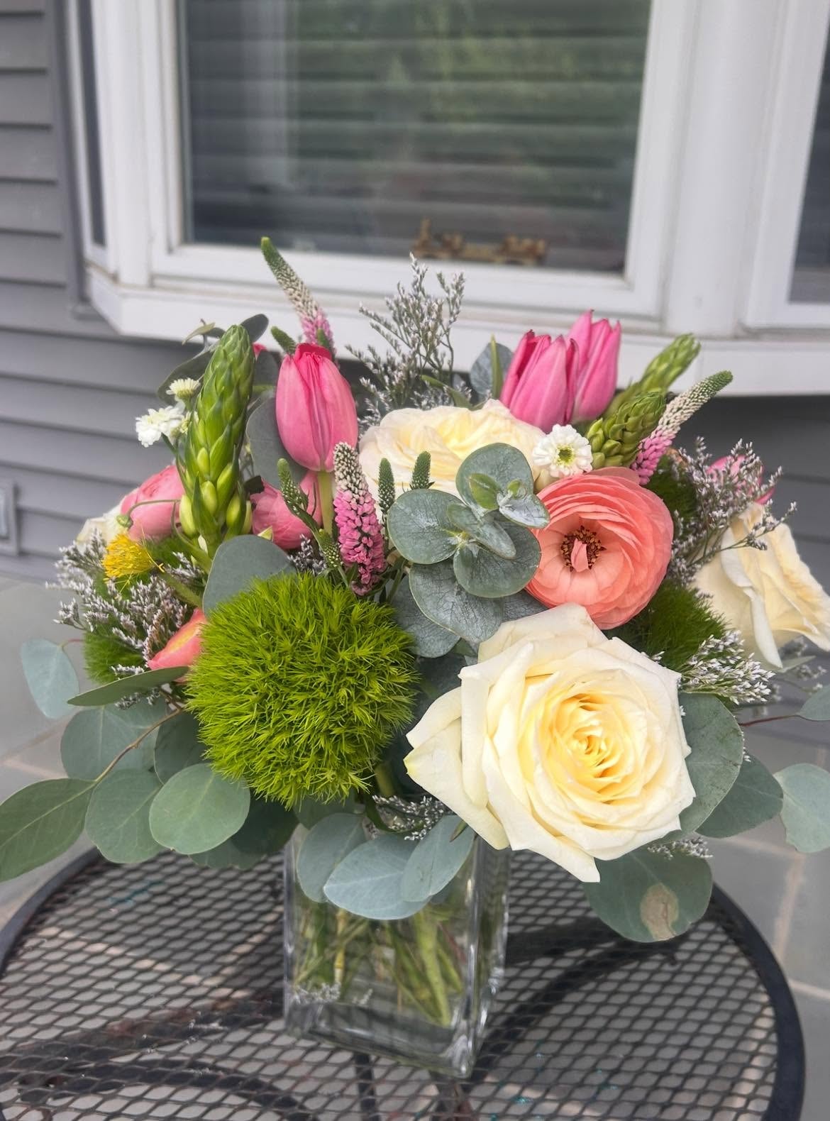 Soft pink and white flower arrangement in white ceramic vase