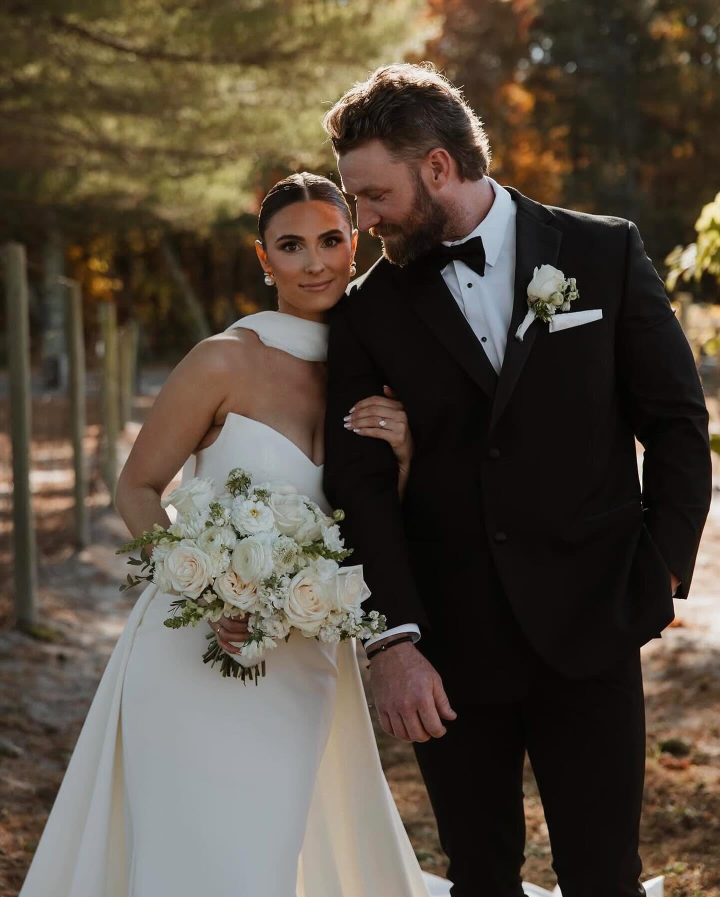 Bride and groom portrait with white rose bouquet in autumn setting
