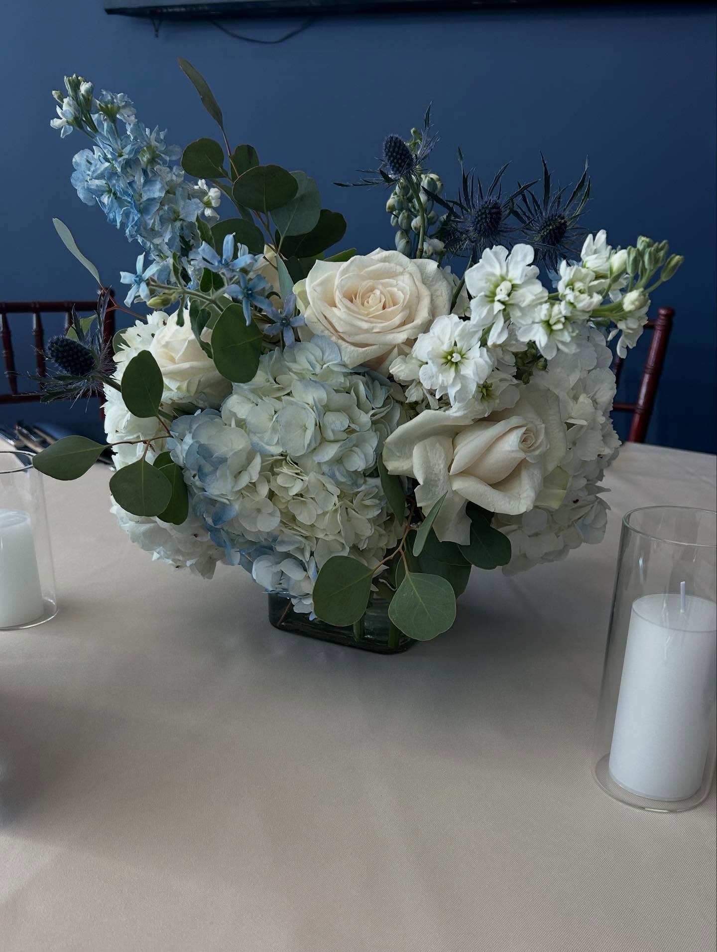 Blue hydrangea and white rose centerpiece arrangement with eucalyptus